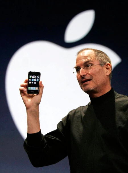The Then Apple CEO Steve Jobs Holds Up The First Iphone